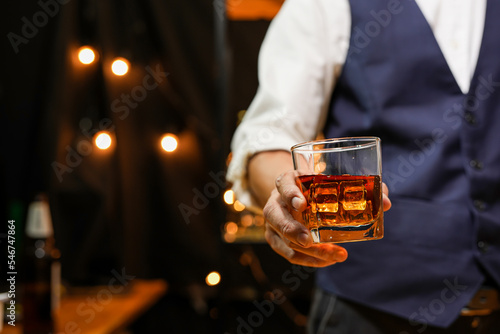 
Bartender pouring Whiskey, on  bar photo