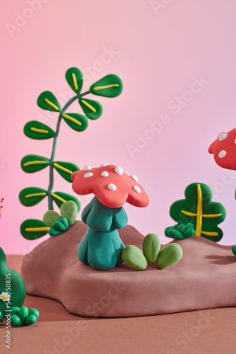 Red plasticine mushrooms handmade on green grass photo