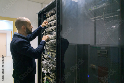 Computer technician man working in a server room photo