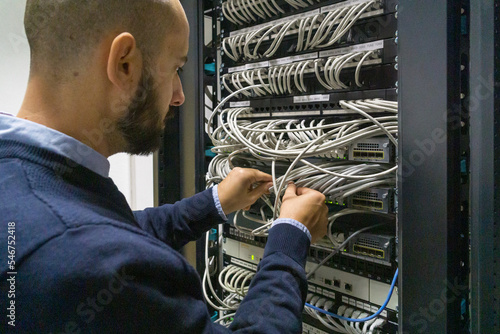 Computer technician working with a server rack photo