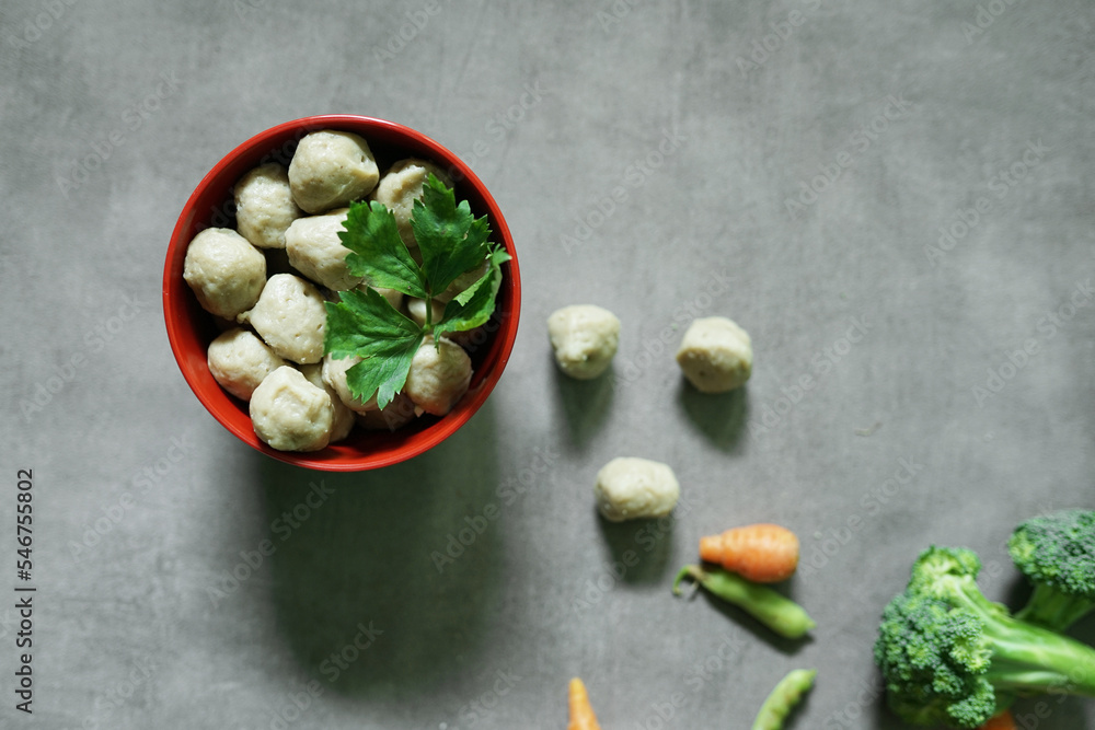 raw meatballs in a bowl with a concrete background raw meatballs in a bowl with a concrete background