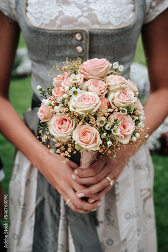 Close up on the hand of a bride with a bridal bouquet 