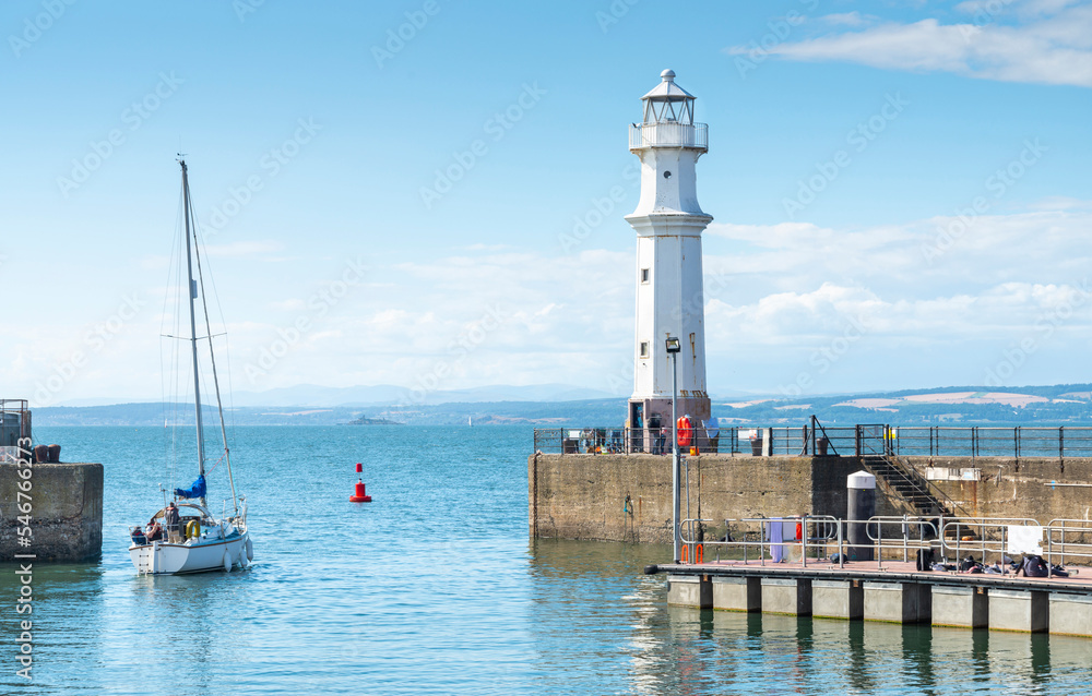Sailing yacht leaving Newhaven harbour ,into the Firth of Forth,Edinburgh,Scotland,UK.