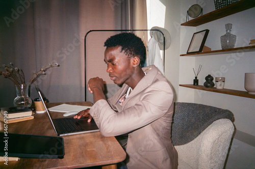 Serious freelancer using netbook at desk at home