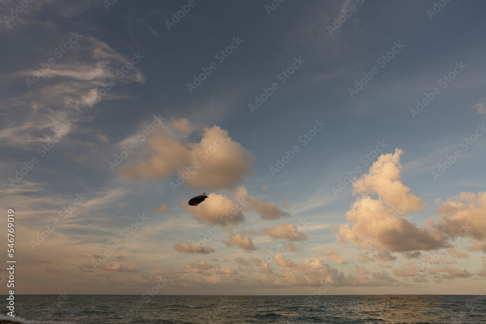 Clouds over the ocean, aircraft in the sky