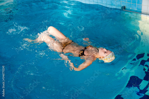 Pretty woman in swimwear relaxing in swimming pool