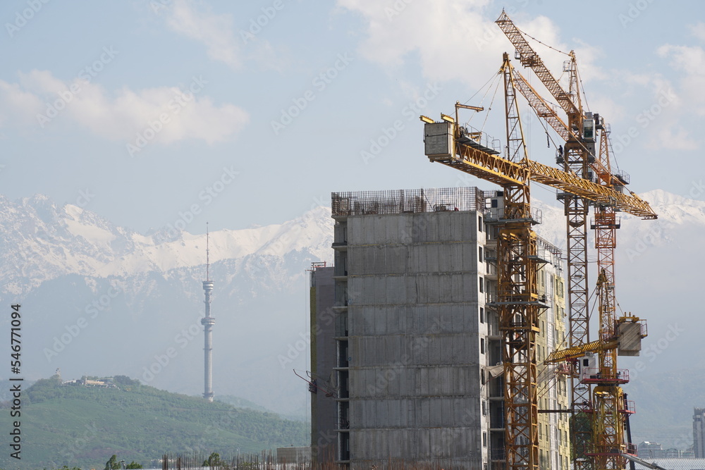 Almaty, Kazakhstan - 04.26.2022 : Construction of a high-rise residential complex near a road junction. Almaty, Kazakhstan - 04.26.2022 : Construction of a high-rise residential complex near a road junction.
