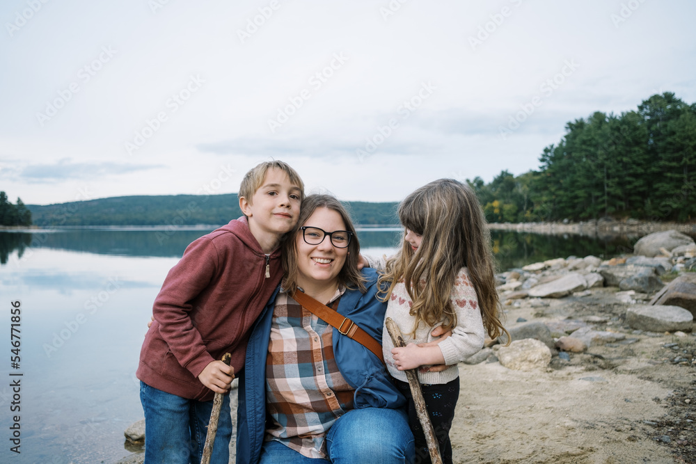 Young smiling mother with her happy children at the lake Young smiling mother with her happy children at the lake