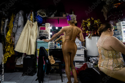 A drag queen strikes a pose in a mirror backstage photo