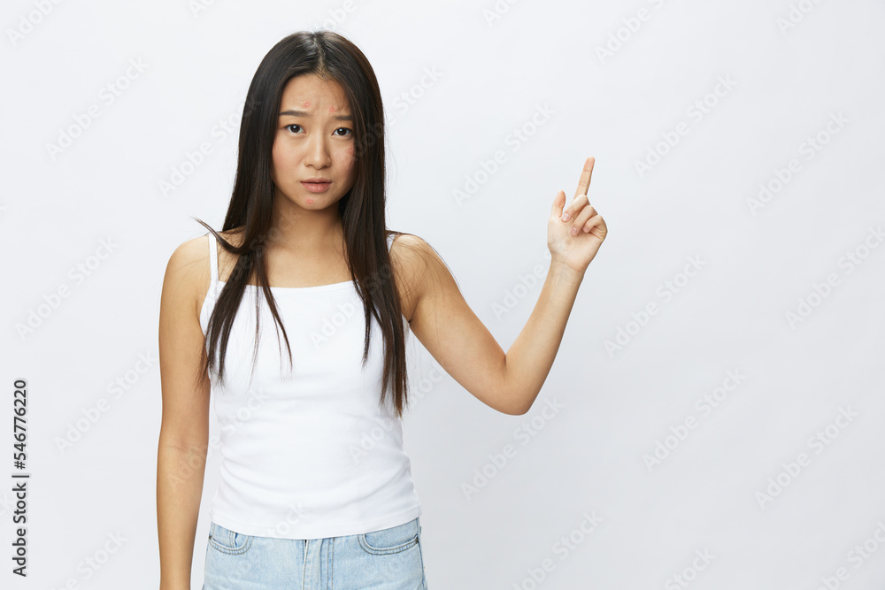 Asian woman hand signals, finger pointing facial skin problems, acne and inflammation, red rash and allergies, chicken pox, sadness from rashes. Facial skin care concept for diseases and nerves Asian woman hand signals, finger pointing facial skin problems, acne and inflammation, red rash and allergies, chicken pox, sadness from rashes. Facial skin care concept for diseases and nerves
