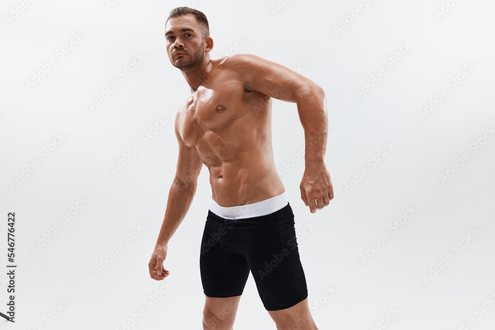 Man athletic body bodybuilder in briefs with naked torso abs full-length in the background, fitness classes. Advertising, sports, active lifestyle, competition, challenge concept. Man athletic body bodybuilder in briefs with naked torso abs full-length in the background, fitness classes. Advertising, sports, active lifestyle, competition, challenge concept.