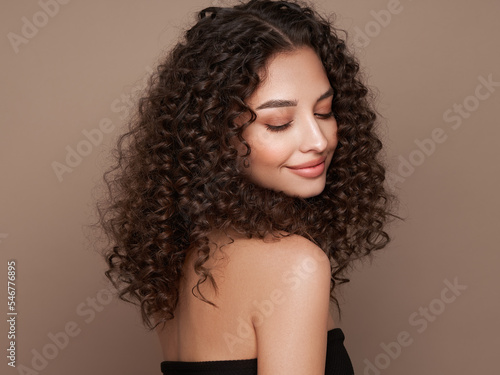Fashion studio portrait of beautiful smiling woman with afro curly hairstyle. Fashion and beauty