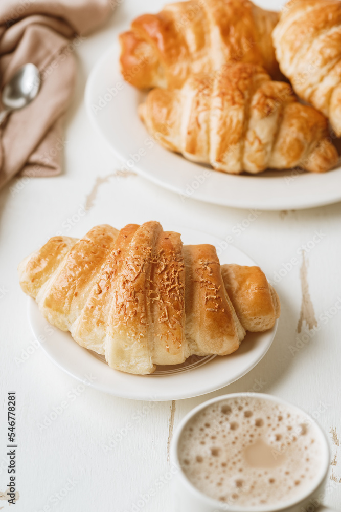 Croissants accompanied with a mug of coffee latte Croissants accompanied with a mug of coffee latte