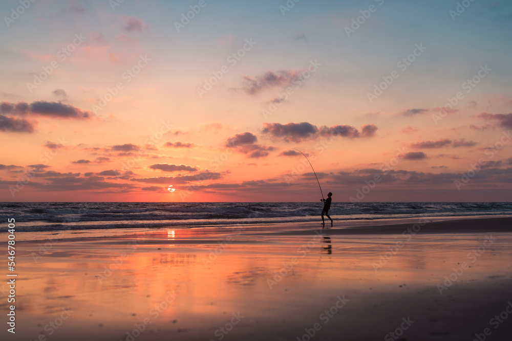 Lucky fisherman silhouette on the shore at sunset Lucky fisherman silhouette on the shore at sunset
