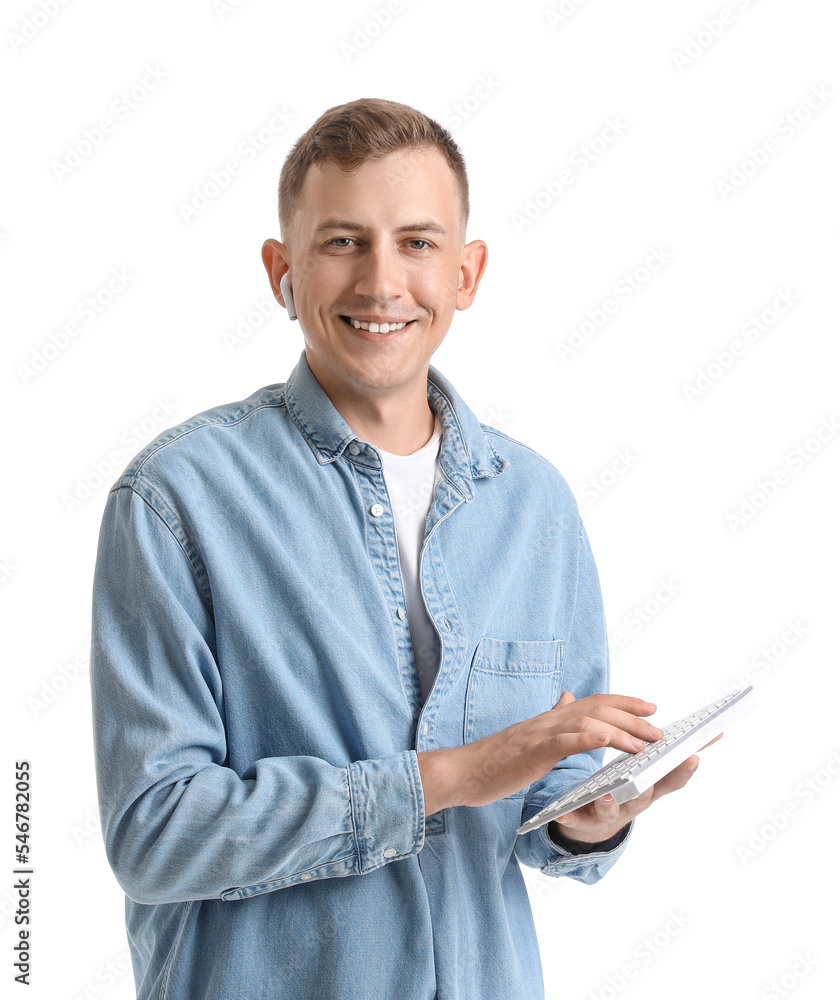 Young man with computer keyboard and earphone on white background Young man with computer keyboard and earphone on white background