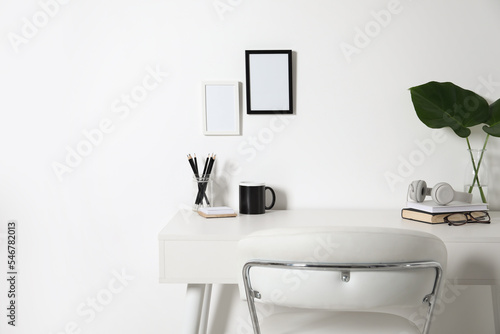 Comfortable workplace with white desk near wall at home © New Africa