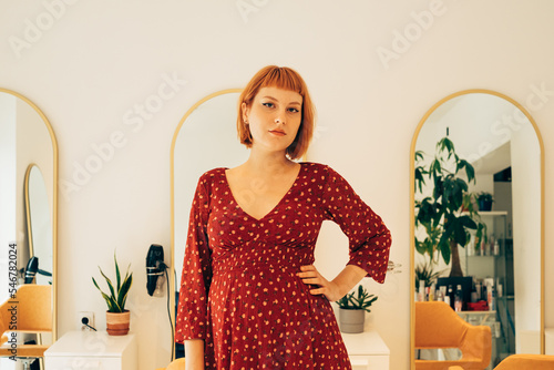 Portrait of Pretty Pregnant Hairdresser in Her Salon photo