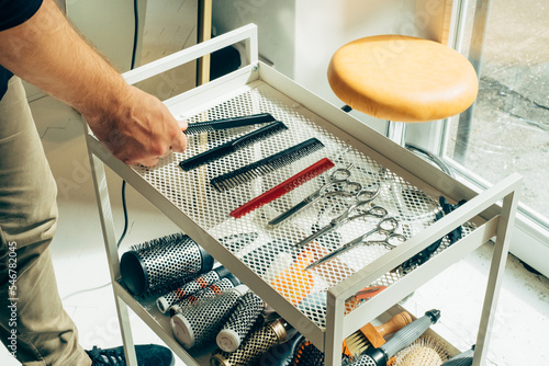 Cropped Image of Hairdresser's Hand Choosing Comb