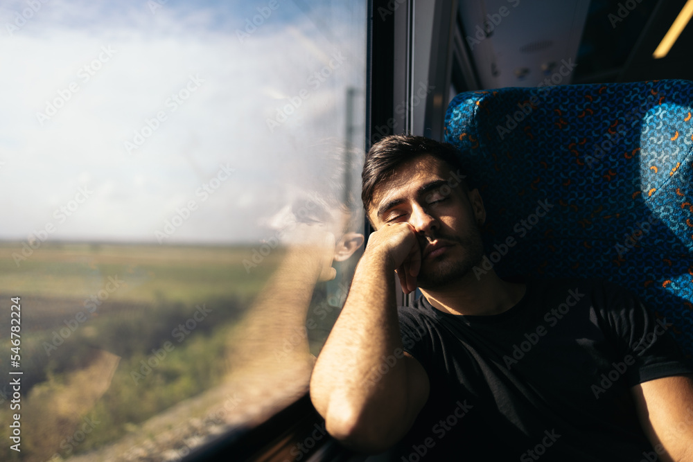 © Pedro Merino/Stocksy - Asleep young man traveling by train © Pedro Merino/Stocksy - Asleep young man traveling by train
