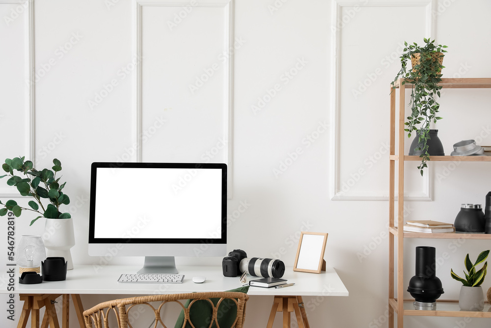 Photographer's workplace with computer and equipment in light office