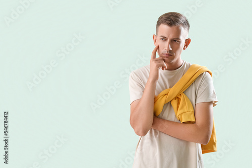 Thoughtful young man on gre...