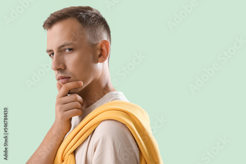 Thoughtful young man on gre...