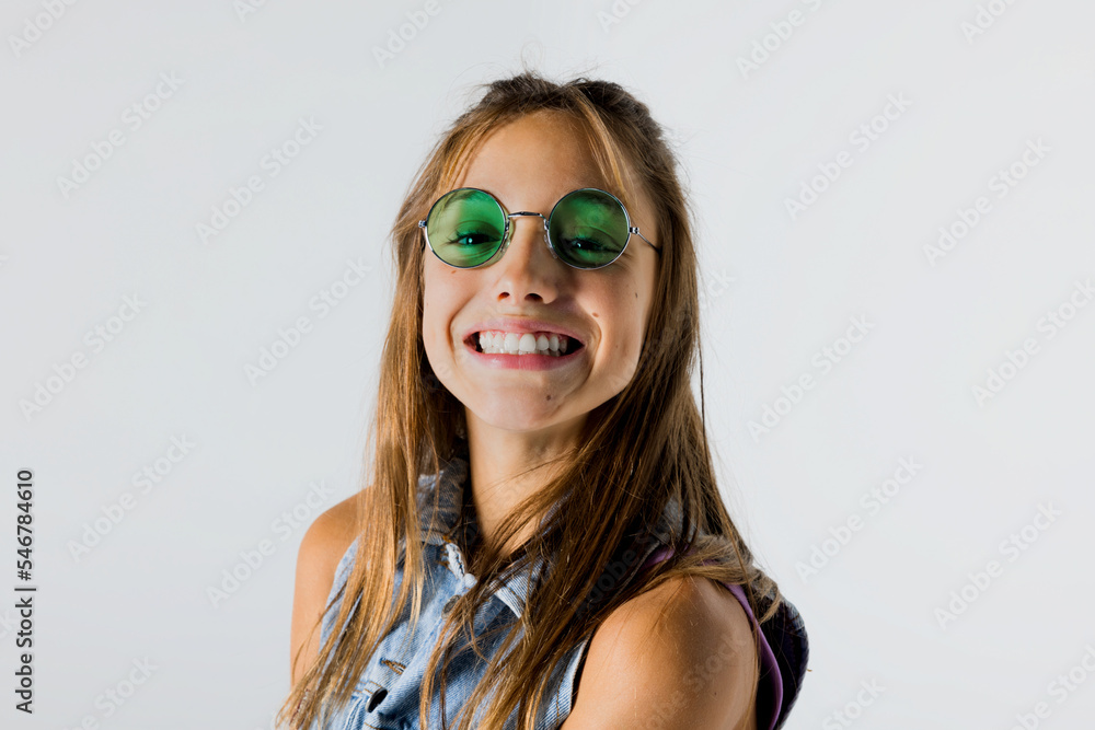 Cheerful young girl in sunglasses posing in studio Cheerful young girl in sunglasses posing in studio
