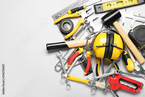 Hearing protectors with builder's tools on light background