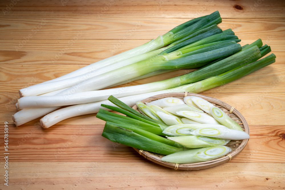 Fresh Japanese Bunching Onion on bamboo basket, Green Japanese spring onions on wooden background. Fresh Japanese Bunching Onion on bamboo basket, Green Japanese spring onions on wooden background.