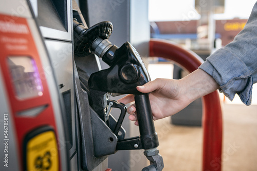 Woman Lifts Gas Pump Nozzle