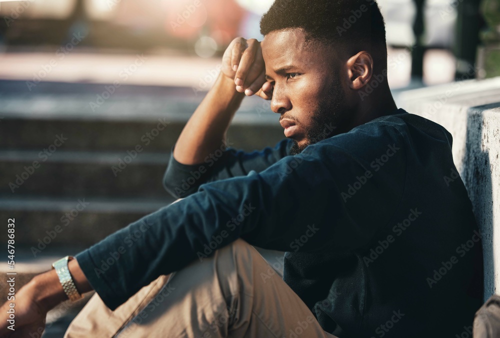 Obraz premium Depressed, angry and black man upset, tired and unhappy outdoor in city, stare and frustrated. Mental health, African American male and young guy with problem, fail and depression being disappointed.