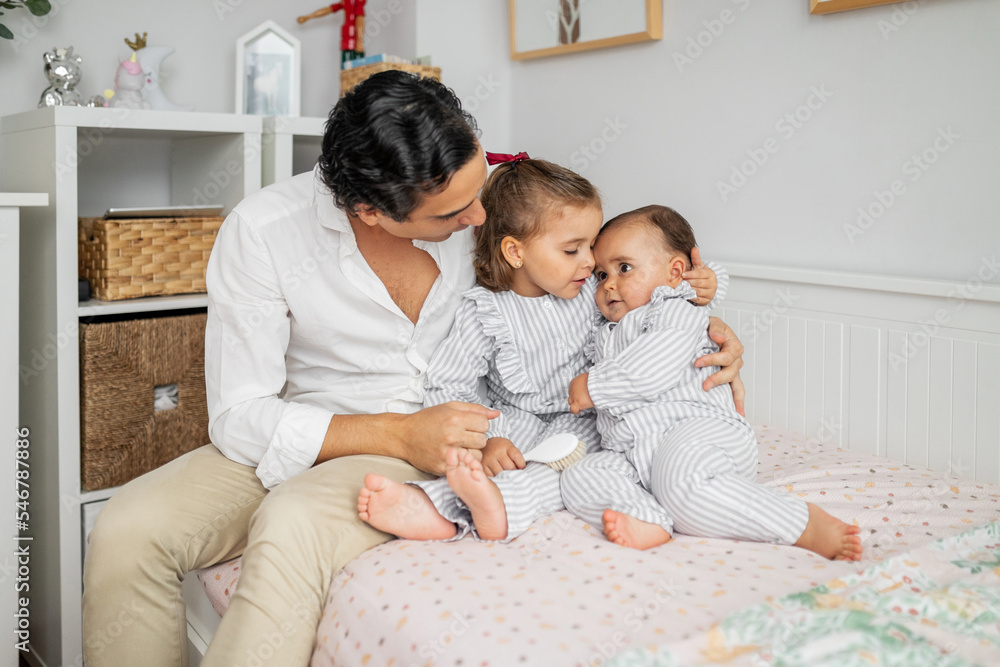 young father with his two small children in the bedroom young father with his two small children in the bedroom