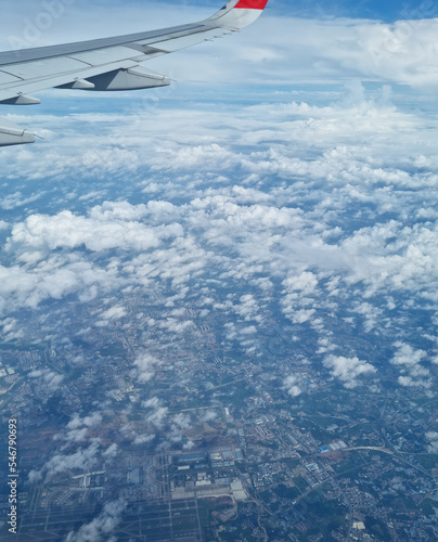 Airplane wing through the clouds in the sky.