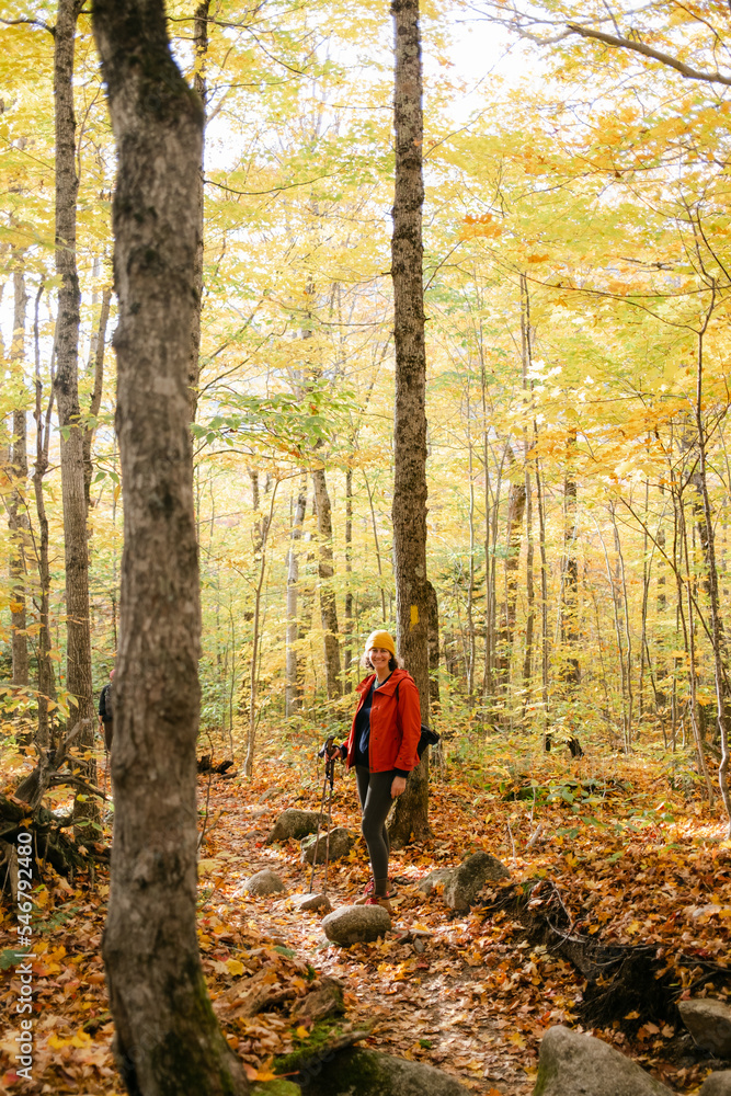 woman in forest during peak foliage in New England  