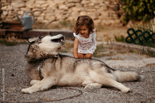 Girl patting dog in backyard.