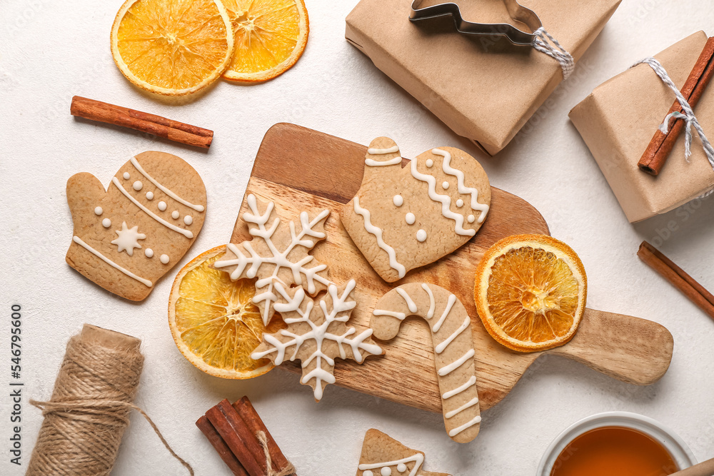 Composition with tasty Christmas cookies, gifts and orange slices on light background Composition with tasty Christmas cookies, gifts and orange slices on light background
