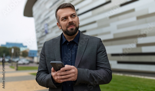 Slika na platnu presentable male businessman holding phone outside