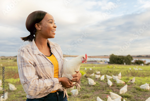 Black woman, chicken farm and happy with small business, growth and agriculture development outdoor in nature. Farmer, animal and sustainability farming with smile and working on countryside poultry photo