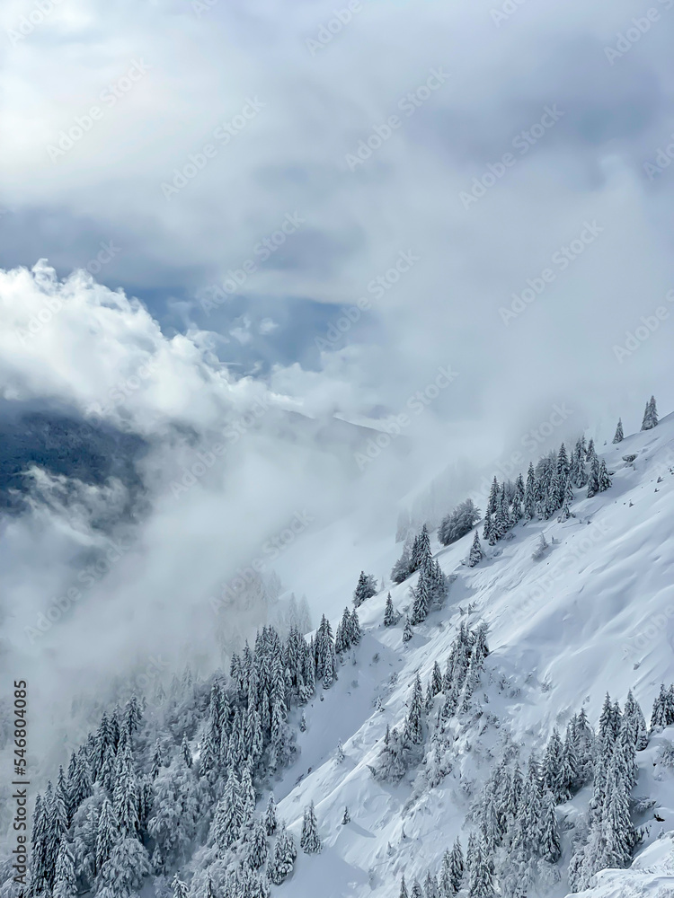 Remains of snowfall clouds rolling across freshly snow-covered mountainside Remains of snowfall clouds rolling across freshly snow-covered mountainside