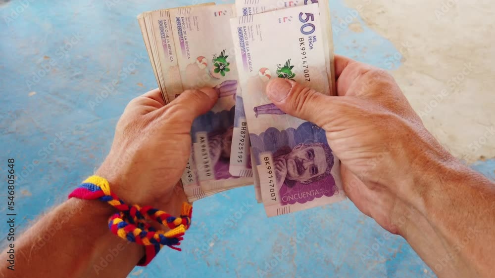 Hands counting money banknotes Colombian Peso ( pesos ) - inflation and economic growth of one of the poorest countries in South America