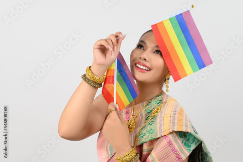 Portrait of Young woman in Thai Northeastern Traditional Clothing holding rainbow flag