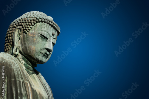 Kamakura Daibutsu bowing his head on blue ackground.