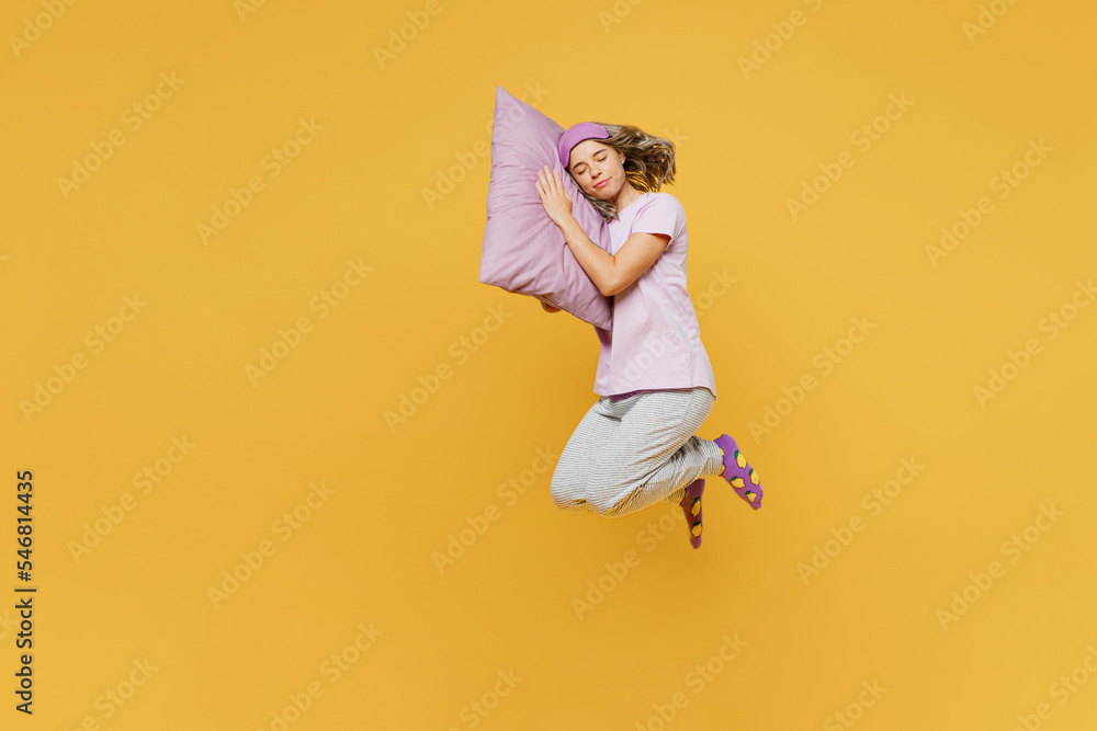 Full body sideways young woman wear purple pyjamas jam sleep eye mask