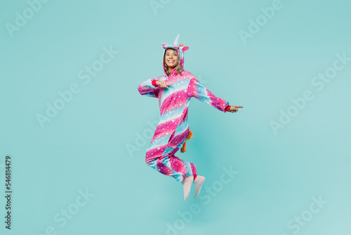 Full body young woman 20s wear domestic costume with hoody and animals ears point index finger aside indicate on workspace area copy space mock up isolated on plain pastel light blue cyan background. © ViDi Studio