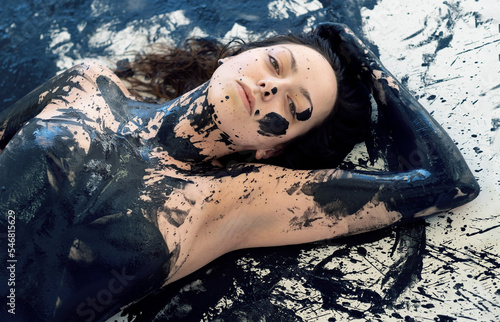 Obraz na plátně portrait of a sexy young brunette woman with dots of black color paint