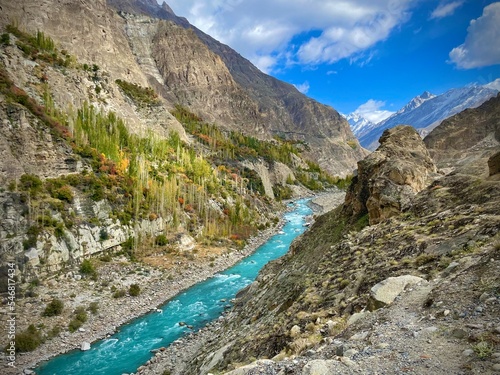 Mountainous Landscape and a bright blue river in Karimabad in the Pakistani-Administered Kashmir Region of Gilgit-Baltistan on a bright day