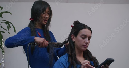 the lifestyle of an Asian stylist and a European makeup artist. happy girls are professionals preparing the model for shooting.