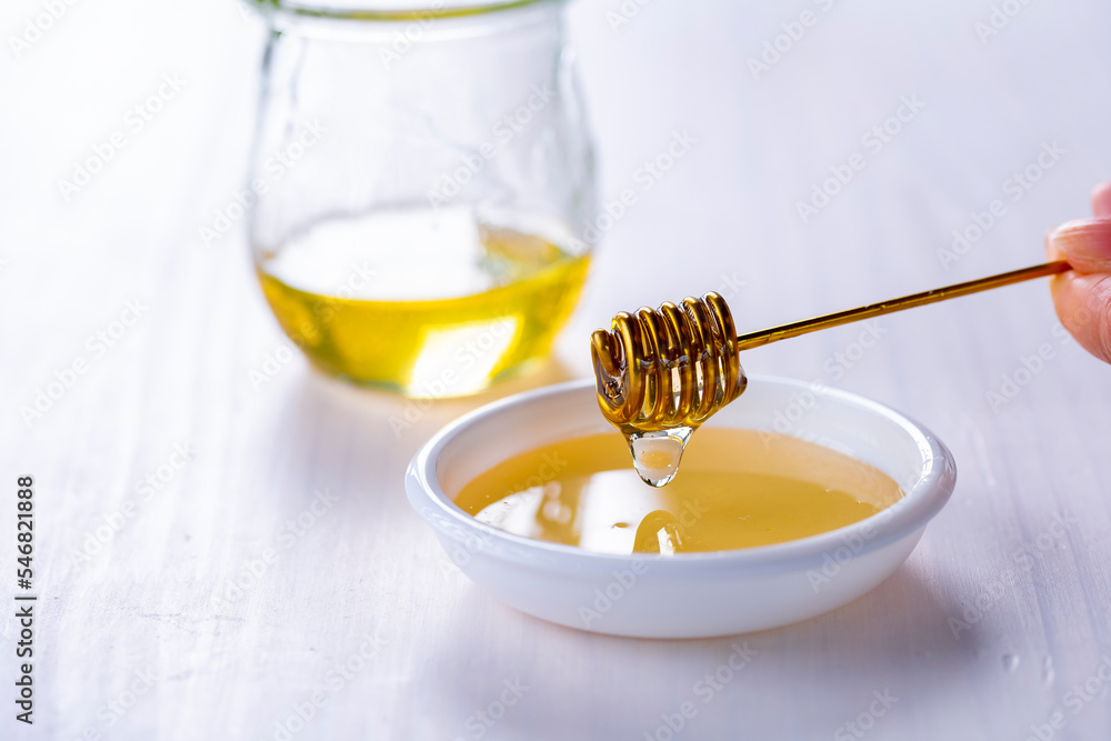 Honey with honey dipper on white table.
Sweet honey image. Honey with honey dipper on white table.
Sweet honey image.