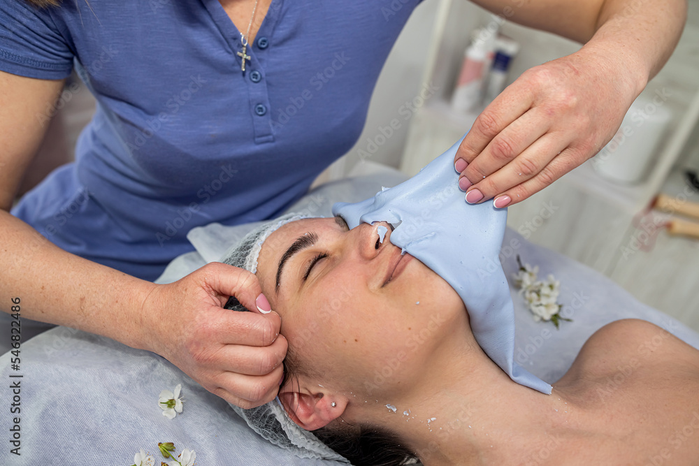 beautician removes the mask from the client in the spa