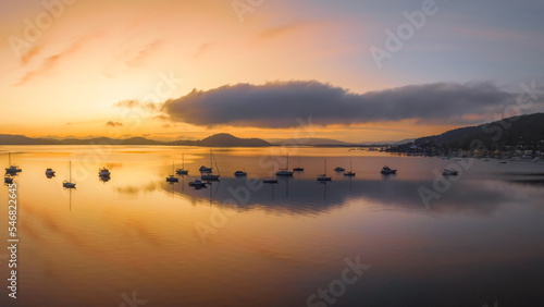 Sunrise over the water with fog  boats  clouds and reflections